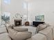 A bright living room with a stone fireplace, modern decor, and large windows that invite ample natural light indoors at 2463 Tavern Way, Castle Rock, CO 80104
