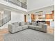 Open-concept living room with view of a modern kitchen, staircase, and large sofa for comfortable gathering at 2463 Tavern Way, Castle Rock, CO 80104