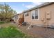 A clean backyard featuring tan siding, small deck with access from living room, and rock ground cover at 8112 Gray Ct # 394, Arvada, CO 80003