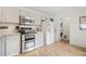 Well-lit kitchen with stainless steel appliances, light gray cabinets, and a convenient washer/dryer area at 8112 Gray Ct # 394, Arvada, CO 80003