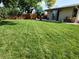 Large backyard with lush green grass, trees, and a wood fence for privacy at 9231 Irving St, Westminster, CO 80031