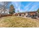 Backyard features a lush lawn, brick details, wood fence and a sliding door to enter the home at 9231 Irving St, Westminster, CO 80031