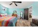 This bedroom offers a colorful bedspread, wood floors, and an open doorway to an adjacent room at 9231 Irving St, Westminster, CO 80031