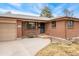 Close-up of a well-maintained brick house featuring an inviting front entry and attached garage at 9231 Irving St, Westminster, CO 80031