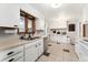 Bright kitchen with white cabinets, neutral counters, and checkered tile flooring offers classic charm at 9231 Irving St, Westminster, CO 80031