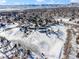 Aerial view of house on snow covered lot with mountain views at 1557 S Pierson St, Lakewood, CO 80232
