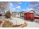 Yard with snow, landscaping and red wooden enclosure at 1557 S Pierson St, Lakewood, CO 80232