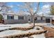 Charming ranch home with a snow-covered front yard at 1557 S Pierson St, Lakewood, CO 80232