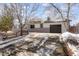 Ranch home with a long driveway and snow-covered yard at 1557 S Pierson St, Lakewood, CO 80232