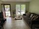 Comfortable living room features tile flooring, a large window, and a sofa with decorative pillows at 2285 S Jasper Way # A, Aurora, CO 80013