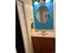 Bright powder room with a vanity, oval mirror, towel rack, and vibrant turquoise accent wall at 2285 S Jasper Way # A, Aurora, CO 80013