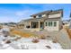 Exterior view of the backyard with covered patio and winter-ready landscaping at 5411 Edenborn Way, Castle Rock, CO 80104