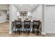 Basement bar featuring pendant lighting, white cabinets, tile backsplash, and barstool seating at 5411 Edenborn Way, Castle Rock, CO 80104