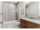 Bathroom with tub and tiled walls, a wood vanity and stone countertop at 5411 Edenborn Way, Castle Rock, CO 80104