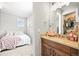 Bathroom vanity with views of a bedroom with a comfy bed and bright window at 5411 Edenborn Way, Castle Rock, CO 80104