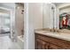Bathroom with a double sink, wood vanity, stone countertop and a tub with tile surround at 5411 Edenborn Way, Castle Rock, CO 80104