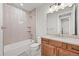 Well-lit bathroom features a tub and shower, a wooden vanity and sink at 5411 Edenborn Way, Castle Rock, CO 80104
