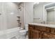 Bathroom featuring tub with tiled walls, a wood vanity and a white stone countertop at 5411 Edenborn Way, Castle Rock, CO 80104