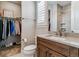 Well-lit bathroom featuring a sink, toilet, and window, with a pass-through to a well-organized walk-in closet at 5411 Edenborn Way, Castle Rock, CO 80104