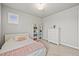 Bright bedroom with carpet, a large window, white dresser, and bookshelf filled with color-coordinated books at 5411 Edenborn Way, Castle Rock, CO 80104