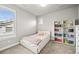Cozy bedroom with large windows, carpet, and a bookshelf, filled with color-coordinated books at 5411 Edenborn Way, Castle Rock, CO 80104