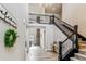 Bright foyer features soaring ceilings, wood floors, wrought iron staircase, and views to the Gathering room at 5411 Edenborn Way, Castle Rock, CO 80104