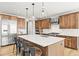 Gourmet kitchen with stainless steel appliances, a large island, pendant lighting, and custom cabinetry at 5411 Edenborn Way, Castle Rock, CO 80104
