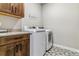 Functional laundry room featuring a stacked washer and dryer, tiled floors, and wood cabinets at 5411 Edenborn Way, Castle Rock, CO 80104