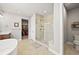 Bright main bathroom with a soaking tub, glass shower, and walk-in closet access at 5411 Edenborn Way, Castle Rock, CO 80104