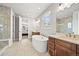 Luxurious bathroom with dual vanities, soaking tub, and glass-enclosed shower at 5411 Edenborn Way, Castle Rock, CO 80104