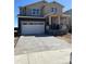 Two-story home with a two-car garage, covered porch, gray siding, and a concrete driveway at 664 Deer Park, Watkins, CO 80137