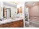 Cozy bathroom with tiled shower/tub, and vanity with tile countertop at 9873 Greensview Cir, Lone Tree, CO 80124