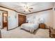Spacious bedroom with a ceiling fan, wood trim, and a view into the bathroom at 9873 Greensview Cir, Lone Tree, CO 80124