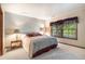 Cozy bedroom featuring plush carpet, large window with blinds, and a comfortable bed with decorative pillows and a lovely border at 9873 Greensview Cir, Lone Tree, CO 80124