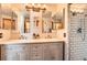 Bathroom featuring double vanity, mirrors, updated lighting, a marble countertop and a tiled shower at 1521 Redtail Ct, Longmont, CO 80504