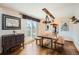 Bright dining area featuring hardwood floors, unique light fixtures, a large wooden table, and a sliding glass door at 1521 Redtail Ct, Longmont, CO 80504