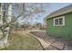 Green backyard with a stone pathway leading to a house with a wooden fence and some trees at 6000 W 29Th Ave, Denver, CO 80214