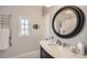 Elegant bathroom featuring a marble vanity, round mirror, and a heated towel rack at 6000 W 29Th Ave, Denver, CO 80214