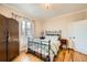 Comfortable bedroom featuring a wrought iron bed frame, hardwood floors, and ample natural light at 6000 W 29Th Ave, Denver, CO 80214