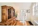 Sunlit entryway with hardwood floors and a classic wooden hutch near the white front door at 6000 W 29Th Ave, Denver, CO 80214