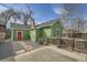 Charming green home with a red door, stone pathway and a rustic wooden fence at 6000 W 29Th Ave, Denver, CO 80214