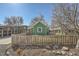 A charming green home with a wooden fence and mature trees in the background at 6000 W 29Th Ave, Denver, CO 80214