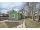 Home exterior featuring green siding, a stone walkway and a well maintained lawn at 6000 W 29Th Ave, Denver, CO 80214
