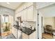 Well lit kitchen featuring white cabinets, black countertops, and decorative tile flooring at 6000 W 29Th Ave, Denver, CO 80214