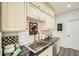The kitchen features white cabinets, black countertops, subway tile, and decorative black and white flooring at 6000 W 29Th Ave, Denver, CO 80214