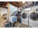 Basement laundry area with modern washer and dryer, utility sink, and convenient access to basement stairs at 4196 Chase St, Denver, CO 80212