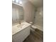 Bathroom with single sink vanity, toilet, and stand up shower with gray marble pattern tile at 521 10Th St, Fort Lupton, CO 80621