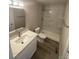 Bathroom with single sink vanity, toilet, and stand up shower with gray marble pattern tile at 521 10Th St, Fort Lupton, CO 80621