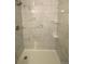 Stand up shower with gray marble pattern tile and built-in shelving at 521 10Th St, Fort Lupton, CO 80621