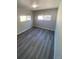 Bedroom featuring gray wood-look floors and two windows at 521 10Th St, Fort Lupton, CO 80621